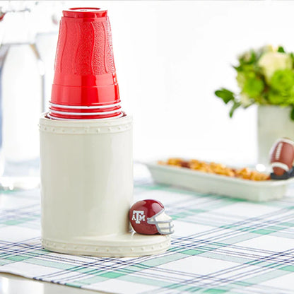 Ceramic cup caddy with stacked red plastic cups and Nora Fleming Texas A&M mini helmet game day accent