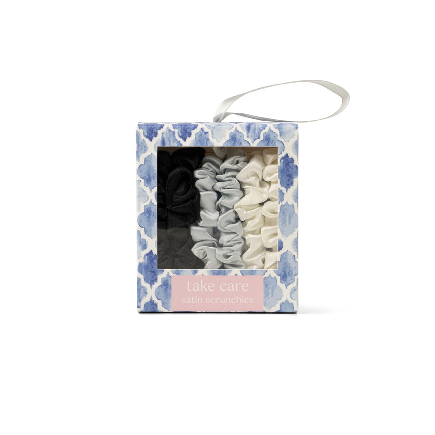 Take Care satin scrunchies set in black gray and cream colors packaged in a blue patterned box
